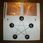 Square wood box with two copper plates and a pentagram connecting five knobs